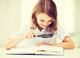 Image showing girl reading book with magnifier at school