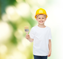 Image showing smiling little boy in helmet with paint brush