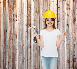 Image showing smiling little girl in hardhat with hammer