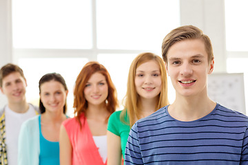 Image showing smiling students with teenage boy in front