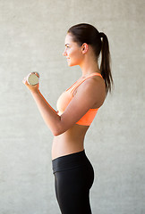 Image showing smiling woman with dumbbells in gym