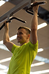 Image showing smiling man exercising in gym