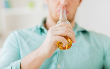 Image showing close up of man drinking beer at home