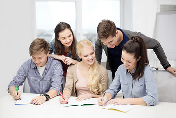 Image showing smiling students with notebooks at school