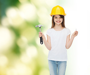 Image showing smiling little girl in hardhat with hammer