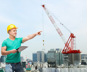 Image showing smiling man in helmet with clipboard