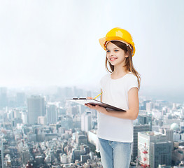 Image showing smiling little girl in hardhat with clipboard