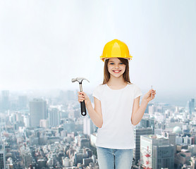 Image showing smiling little girl in hardhat with hammer