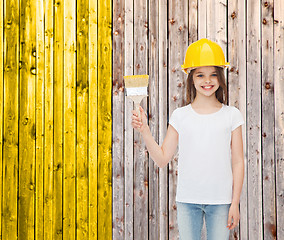 Image showing smiling little girl in helmet with paint brush