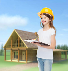 Image showing smiling little girl in hardhat with clipboard