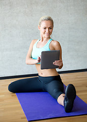 Image showing smiling woman with tablet pc in gym