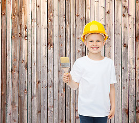 Image showing smiling little boy in helmet with paint brush
