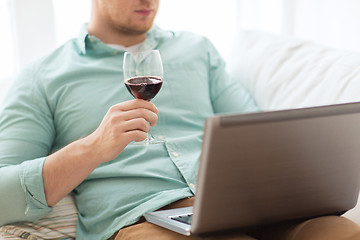 Image showing close up of man with laptop and wine glass