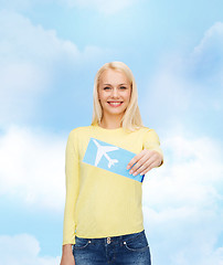 Image showing smiling young woman with airplane ticket