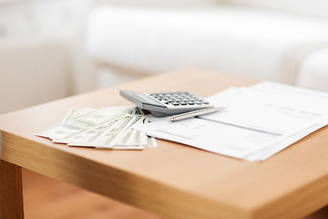 Image showing close up of money and calculator on table at home