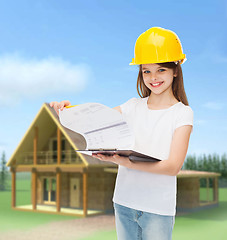 Image showing smiling little girl in hardhat with clipboard