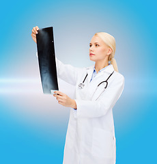 Image showing serious female doctor looking at x-ray