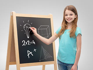 Image showing happy little girl with blackboard and chalk