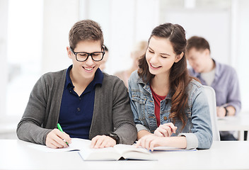 Image showing two teenagers with notebooks and book at school