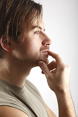 Image showing Attractive man with green shirt looks thoughtful