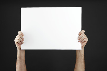 Image showing Man holds up poster