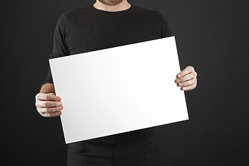 Image showing Man holds up poster