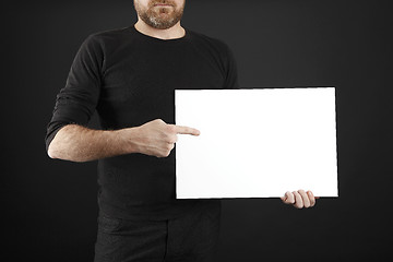 Image showing Man holds up poster