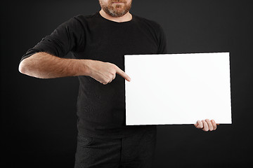 Image showing Man holds up poster