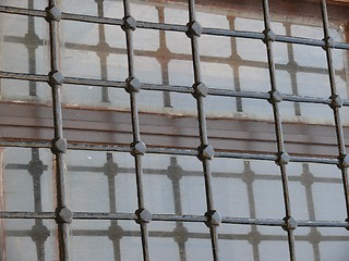 Image showing Close up of dirty glass window behind iron bars