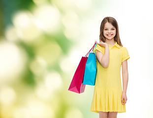 Image showing smiling little girl in dress with shopping bags