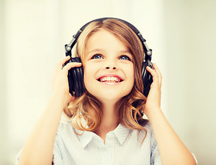 Image showing little girl with headphones at home