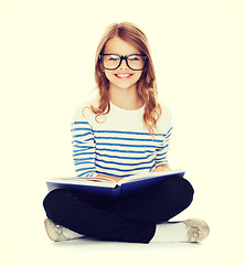 Image showing smiling little student girl sitting on the floor