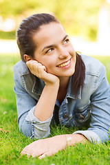 Image showing smiling young girl lying on grass