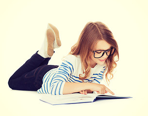 Image showing smiling little student girl lying on the floor