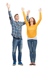 Image showing smiling teenagers with raised hands