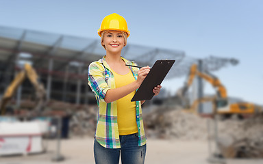 Image showing smiling woman in helmet with clipboard