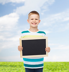 Image showing smiling little boy holding blank black chalkboard