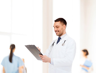 Image showing smiling male doctor with clipboard and stethoscope