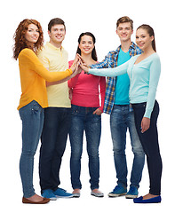 Image showing group of smiling teenagers making high five