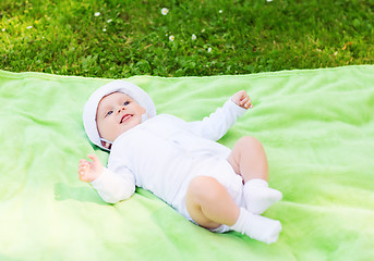 Image showing smiling baby lying on floor and looking up