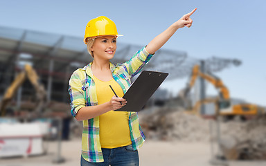 Image showing smiling woman in helmet with clipboard