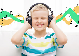 Image showing smiling little boy with headphones at home