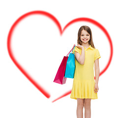 Image showing smiling little girl in dress with shopping bags