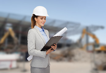 Image showing smiling architect in helmet with blueprint