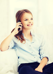 Image showing smiling girl with smartphone at home