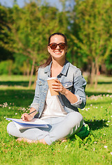 Image showing smiling young girl with notebook and coffee cup