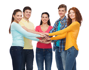 Image showing smiling teenagers with hands on top of each other