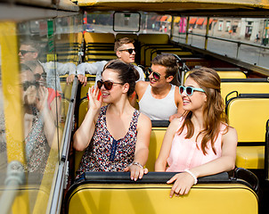 Image showing group of smiling friends traveling by tour bus