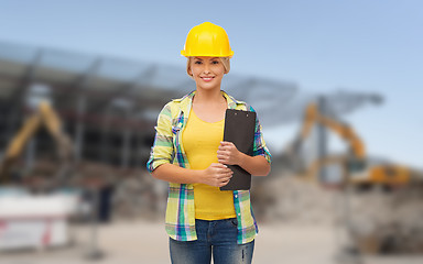 Image showing smiling woman in helmet with clipboard