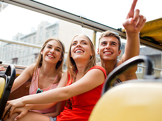 Image showing group of smiling friends traveling by tour bus